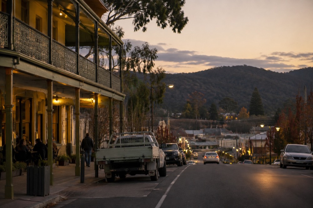 Evening light over a small valley township with a hotel verandah in the foreground