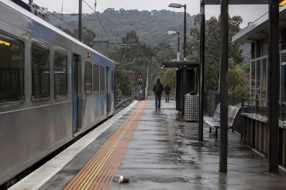 A regional train platform at the edge of the suburbs with hills beyond