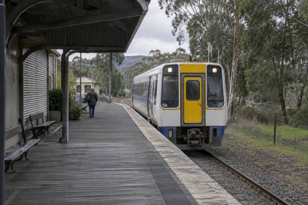 A country railway platform with a regional train stopped beside it