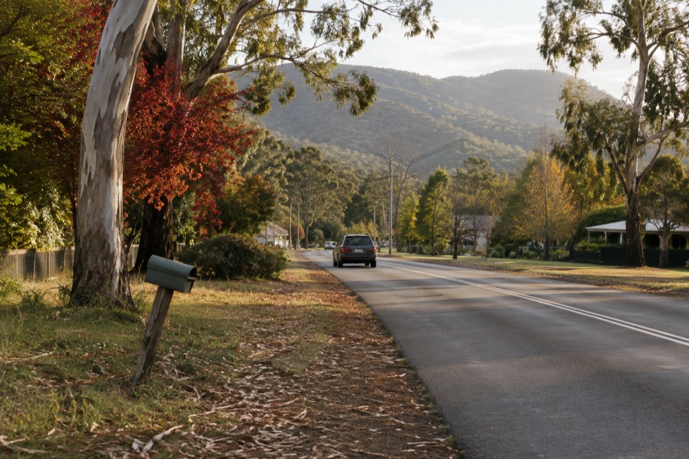 Quiet country road lined with gum trees leading into Healesville