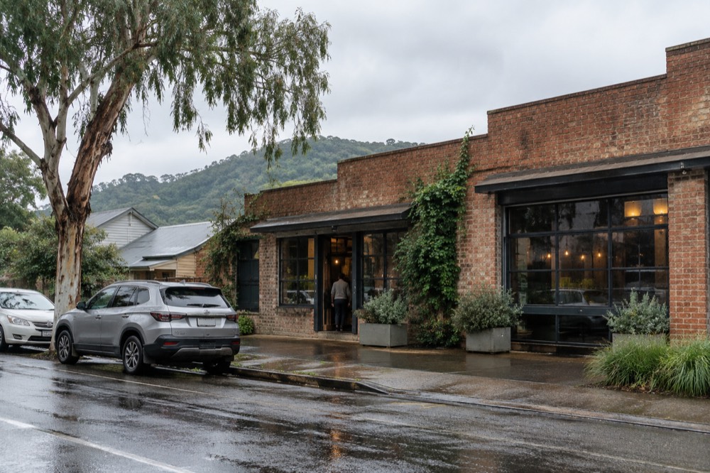 A small-town street with cellar door and brewery signage along the footpath