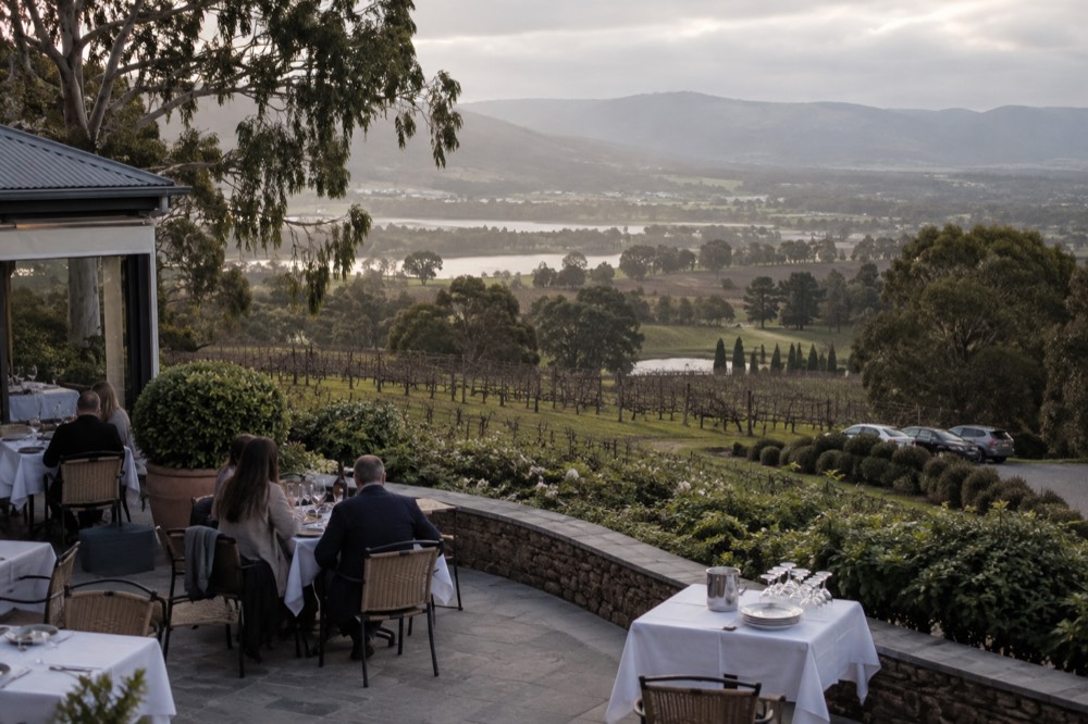 Restaurant terrace at a winery with white tablecloths and a view over the Yarra Valley
